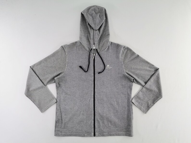 May include: A heather gray zip-up hoodie featuring long sleeves, a hood with black drawstring cords, and a full-length black front zipper. A small white graphic logo is printed on the upper left chest area of the garment.
