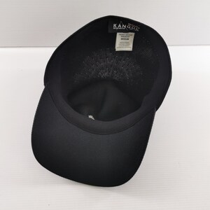 Puede incluir: Gorra de b&eacute;isbol negra con visera curva. La gorra tiene un dise&ntilde;o estructurado y presenta la marca "KANGOL" en el interior. La gorra es de talla mediana.