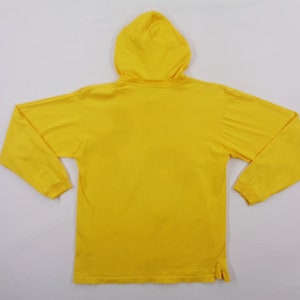 Op de afbeelding: Een felgele hoodie met lange mouwen. Het kledingstuk heeft een capuchon, lange mouwen en een rechte zoom. Het materiaal lijkt zacht en licht van gewicht, ideaal voor vrijetijdskleding. De achterkant van de trui is zichtbaar.