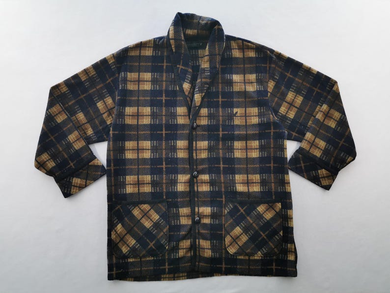 Puede incluir: Chaqueta a cuadros en tonos azul marino y marr&oacute;n. La chaqueta tiene cuello chal, dos bolsillos delanteros y tres botones. El estampado de cuadros es un dise&ntilde;o cl&aacute;sico, adecuado para uso informal. La chaqueta est&aacute; hecha de un material suave y c&aacute;lido.