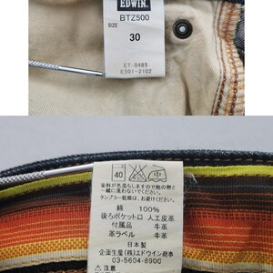 Pu&ograve; includere: Primo piano di un paio di jeans in denim con etichette. Le etichette mostrano il marchio "EDWIN", il modello "BTZ500" e la taglia "30". Ulteriori etichette forniscono istruzioni per la cura e la composizione del materiale, tra cui 100% cotone.