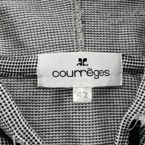 May include: A black and white micro-patterned garment featuring a white rectangular fabric label stitched at the neckline. The label displays the brand name courr&egrave;ges in black lowercase letters with a logo above it and a smaller tag below reading 42.