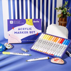 Op de afbeelding: Een set van 30 watergebaseerde acrylmarkers met een penseelpunt. De markers zijn gerangschikt in een doos met een kleurrijk ontwerp en de tekst "Arrtx Acrylic Marker Set".