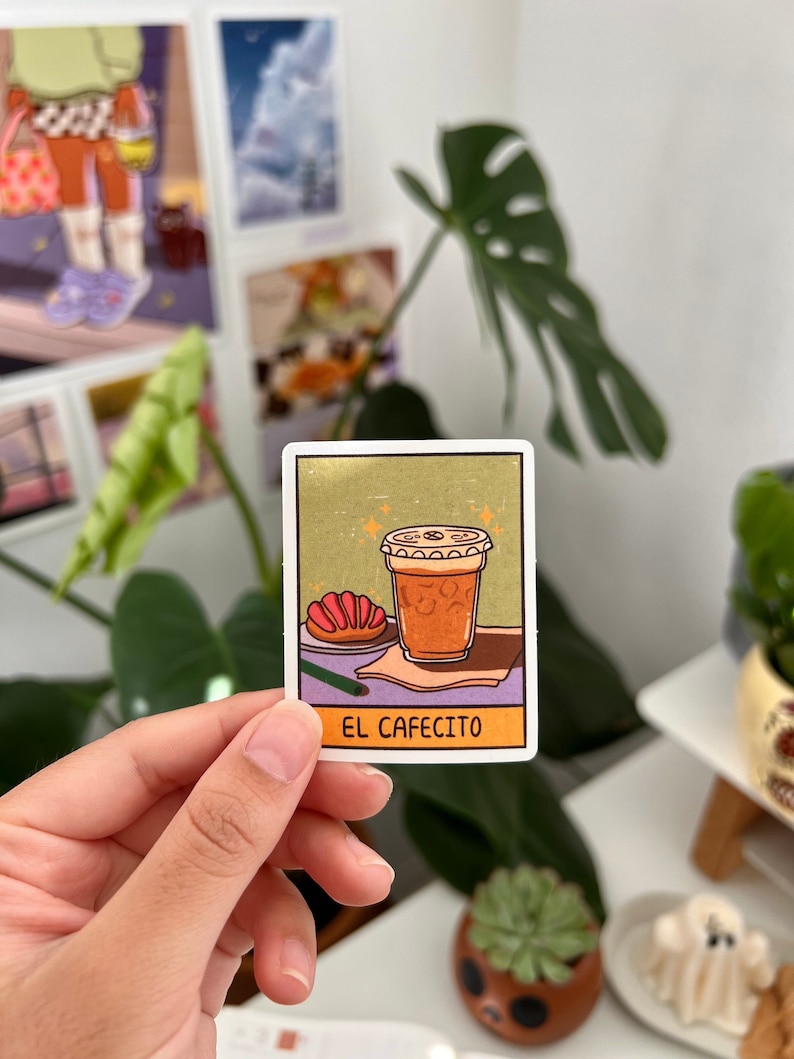 Pode incluir: Um adesivo com uma ilustra&ccedil;&atilde;o de desenho animado de uma x&iacute;cara de caf&eacute; com um pastel em um prato. O texto "EL CAFECITO" est&aacute; impresso abaixo da imagem.