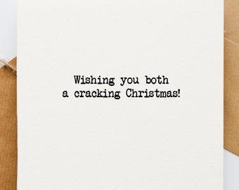 Peut inclure: Une carte blanche avec du texte noir qui dit "Wishing you both a cracking Christmas!"