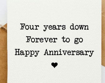 May include: A white card with black text that reads "Four years down Forever to go Happy Anniversary" with a small black heart at the bottom.