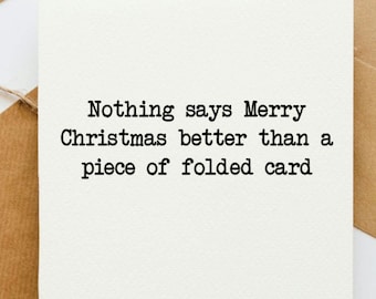Peut inclure: Carte pliée blanche avec le texte "Nothing says Merry Christmas better than a piece of folded card" en noir. La carte est sur une enveloppe marron.