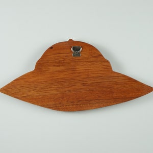 Peut inclure: Une d&eacute;coration murale en bois en forme de soucoupe volante avec un crochet m&eacute;tallique au dos.