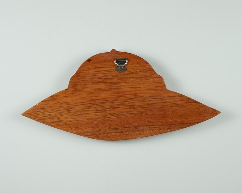 Peut inclure: Une d&eacute;coration murale en bois en forme de soucoupe volante avec un crochet m&eacute;tallique au dos.