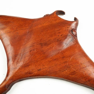 Op de afbeelding: Een handgesneden houten sculptuur van een mantarog. Het beeld is gemaakt van een rijk, roodbruin hout en heeft een gladde, gepolijste afwerking.