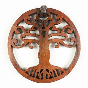 May include: A circular wooden wall hanging with a carved tree of life design. The tree has intricate branches and roots, and the wood is a rich brown color.