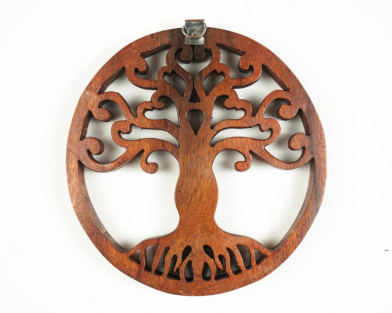 May include: A circular wooden wall hanging with a carved tree of life design. The tree has intricate branches and roots, and the wood is a rich brown color.