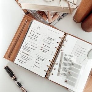 Printable Daily Inserts for Ring Planners, along with coordinating stickers and other accessories, create a well-organized and stylish planner setup.