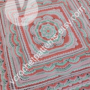 K&ouml;nnte beinhalten: Eine geh&auml;kelte Decke mit einem quadratischen Design in der Mitte. Die Decke ist in verschiedenen Farben gehalten, darunter Rosa, Gr&uuml;n und Wei&szlig;. Die Decke hat einen gewellten Rand.