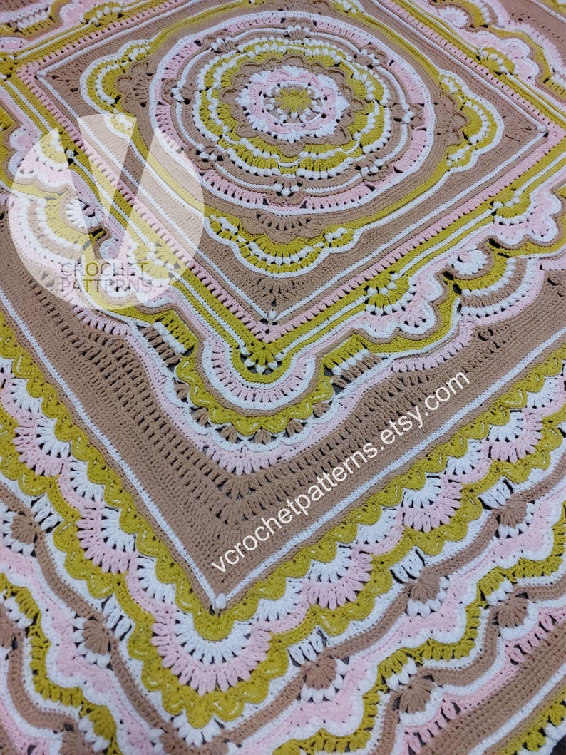 Pode incluir: Um cobertor de croch&ecirc; com um design circular no centro. O cobertor &eacute; feito com fio marrom, branco, rosa e amarelo. O cobertor tem uma borda festonada. O texto "vcrochetpatterns.etsy.com" &eacute; vis&iacute;vel no canto inferior direito.