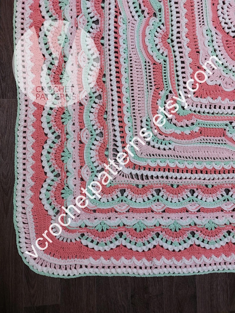 K&ouml;nnte beinhalten: Eine geh&auml;kelte Decke mit quadratischer Form und einem mehrfarbigen Rand. Der Rand besteht aus mehreren Reihen verschiedener Maschen, darunter Muscheln, Picots und Noppen. Die Farben der Decke sind rosa, wei&szlig; und gr&uuml;n.