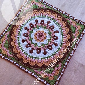 Peut inclure: Une couverture carrée au crochet avec un motif mandala détaillé. La palette de couleurs comprend des nuances de marron, blanc, rose, vert et orange. Le texte "CROCHET PATTERNS" et "vcrochetpatterns.etsy.com" sont visibles.