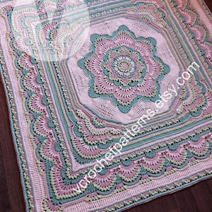 以下が含まれることがあります： 柔らかいパステルカラーの手作りの正方形のかぎ針編みブランケット。ブランケットは、ピンクとティールの中央の花柄のデザインが特徴で、複雑なパターンとスカラップエッジで囲まれています。「wcrochetpatterns.etsy.com」の文字が見えます。