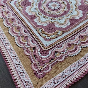Peut inclure: Une couverture au crochet avec un grand motif floral complexe dans des tons de rose, blanc et beige. La couverture est de forme carr&eacute;e et a une bordure d&eacute;licate.