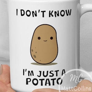 May include: White ceramic mug with a brown cartoon potato with a smiling face. The mug has black text that reads "I don't know I'm just a potato" and a small logo that reads "MC MattCollins Designs".