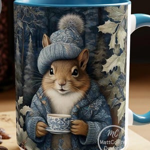 Puede incluir: Una taza de cerámica blanca con un borde y un asa azules presenta una ardilla que lleva un gorro y una bufanda de punto azules, sosteniendo una taza de té azul y blanca. La taza tiene un fondo de escena de bosque con árboles y hojas.