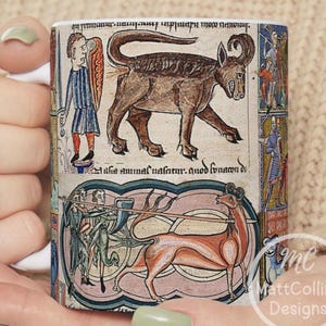 May include: White ceramic mug featuring medieval illustrations of animals and figures in shades of brown, red, and blue. The mug has a wraparound design with detailed artwork and a white handle.