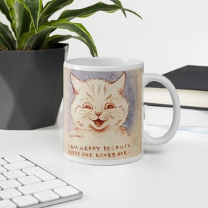 Pu&ograve; includere: Tazza in ceramica bianca con un'illustrazione di un gatto bianco sorridente e il testo "Sono felice perch&eacute; tutti mi amano."