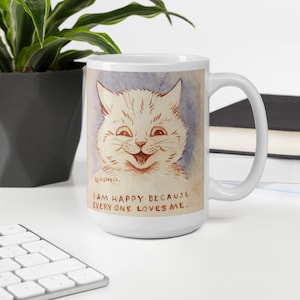 Pu&ograve; includere: Tazza in ceramica bianca con un'illustrazione di un gatto sorridente in stile cartone animato. Il testo sulla tazza recita "Sono felice perch&eacute; tutti mi amano."