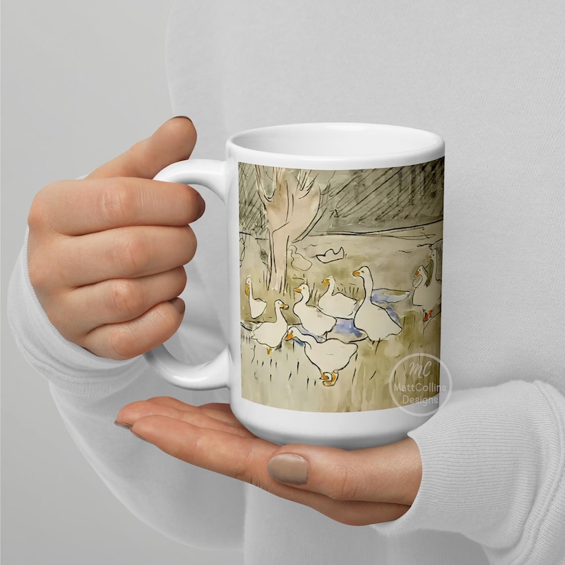 May include: White ceramic coffee mug with a watercolor illustration of a group of geese in a pond. The geese are white with orange beaks and feet. The background is a light brown with a dark brown tree in the background. The mug has a black handle and the text "Matt Collins Designs" is printed on the bottom right corner.