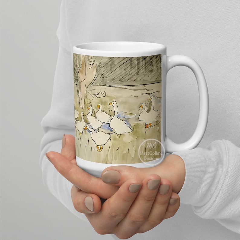 May include: White ceramic mug with a watercolor illustration of a group of geese in a pond. The illustration is in shades of gray, brown, and white. The mug has a black handle and the text "Matt Collins Designs" is printed on the bottom.
