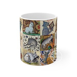May include: White ceramic mug featuring a medieval-style illustration of cats in various poses. The design includes a patchwork of images with ornate floral and scrollwork backgrounds. The mug has a glossy finish and a standard handle.