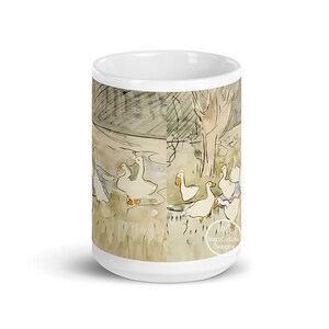 May include: White ceramic coffee mug with a watercolor illustration of geese in a pond. The illustration is in shades of brown, gray, and blue. The text "Matt Collins Designs" is at the bottom of the mug.