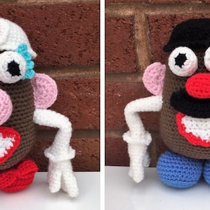 Puede incluir: Dos muñecos de Mr. y Mrs. Potato Head hechos a crochet. La muñeca femenina lleva un gorro de enfermera blanco con una cruz roja y pestañas azules. El muñeco masculino lleva un sombrero negro. Ambos muñecos tienen un cuerpo marrón, orejas rosas, brazos blancos y una boca roja.