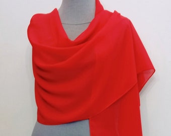 May include: A bright red chiffon scarf draped over a mannequin. The scarf is lightweight and sheer, with a soft, flowing texture.