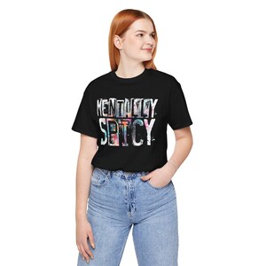 Puede incluir: Camiseta negra con el texto "MENTALLY SPICY" en fuente blanca, colorida y desgastada. La modelo lleva vaqueros azules. La camiseta es una prenda informal para el d&iacute;a a d&iacute;a.
