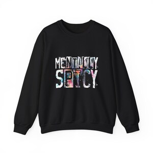 Puede incluir: Sudadera negra de cuello redondo con las palabras "MENTALLY SPICY" en letras blancas. Las letras tienen un relleno colorido, como de acuarela. Una prenda superior informal y c&oacute;moda para el uso diario.