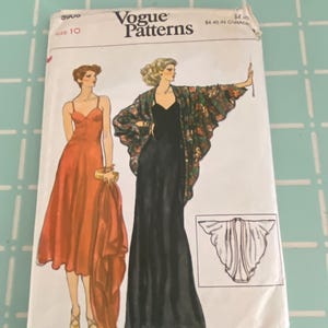 May include: Vogue Patterns sewing pattern, size 10, featuring illustrations of two women in elegant evening gowns. One woman wears a long black dress, and the other wears a red dress. The pattern includes a floral print shawl.