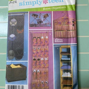 May include: A Simplicity Home Decorating sewing pattern envelope 5124 for simply teen room organizers by Andrea Schewe. The package displays illustrations of various hanging storage solutions, including a hat rack, a photo display, and shelves.