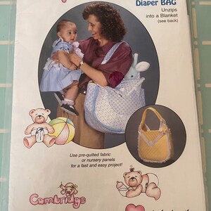 May include: A sewing pattern for a diaper bag that unzips into a blanket. The pattern features a blue and white quilted fabric with a yellow and white trim. The pattern is from Cambridge, where love is stitched into the heart of the family.