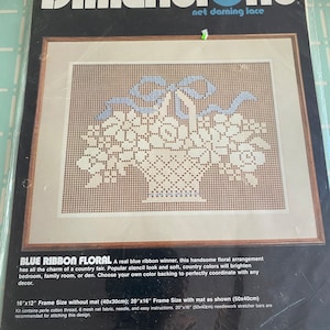 May include: Blue Ribbon Floral net darning lace embroidery kit by Dimensions. The kit includes 6 mesh net fabric, perle cotton thread, a needle, and easy instructions. The finished design measures 16 inches by 12 inches and can be framed with a mat to fit a 20 inch by 16 inch frame.