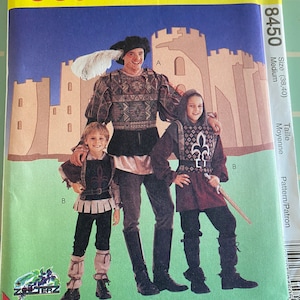 May include: A vintage sewing pattern for three medieval costumes. The pattern is for sizes 38-40 and is labeled "8450". The pattern shows three figures: a man, a woman, and a child. The man is wearing a tunic, leggings, and boots. The woman is wearing a tunic, leggings, and boots. The child is wearing a tunic, leggings, and boots. The pattern is for stretch knits only.
