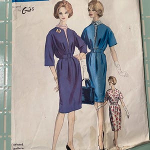 May include: Vintage Vogue Paris Original sewing pattern. The pattern features illustrations of three dresses in shades of blue and pink. The pattern is labeled "Designed by Grès" and includes the number 1039.