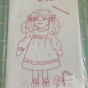 May include: A black and white line drawing of a rag doll with a red bow in her hair. The drawing is on a white sheet of paper with the text "barbara lee's rag dolls 28" x 46" 12 DESIGNS INCLUDED 163053 $ 6.25" printed on it.