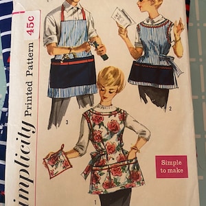 May include: Vintage Simplicity sewing pattern number 3206 for three aprons. The pattern is for a medium size and is 45 cents. The aprons are shown on three models. One apron is striped blue and white, another is striped blue and white with a floral print, and the third is a solid blue apron with a floral print.