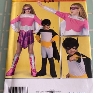 Peut inclure: Patron de couture Simplicity numéro 2567 pour costumes d'enfants. Le patron comprend trois costumes : un costume de super-héros rose et blanc, un costume de chauve-souris jaune et noir et un costume de chauve-souris blanc et jaune. Le patron est disponible pour les tailles 3, 4, 6 et 6. Le patron est disponible sur simplicity.com.