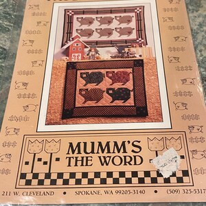 May include: A brown and tan patchwork quilt pattern featuring pigs. The pattern is titled "Patchwork Pigs" and is from "Mumm's The Word".