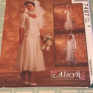 May include: A vintage McCall's sewing pattern for a wedding dress. The pattern is for size 8 and is called "Alicyn Exclusives". The pattern shows a white wedding dress with a lace bodice and a skirt with a slight train. The dress is shown on a model with a veil and a crown.