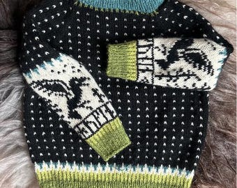 May include: A black knitted jumper with a white dot pattern and bird design on the sleeves. The jumper has a teal collar and cuffs, and a green hem and sleeve cuffs. The jumper is made of a soft, warm material.
