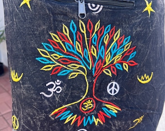 May include: Black canvas tote bag with colourful embroidery of a tree of life, peace symbol, and Om symbol. The bag has a zipped pocket and a button closure.