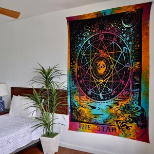 May include: A tie-dye tapestry with a black background featuring a colorful star and the text "THE STAR". The star is surrounded by a circle with astrological symbols and a crescent moon.